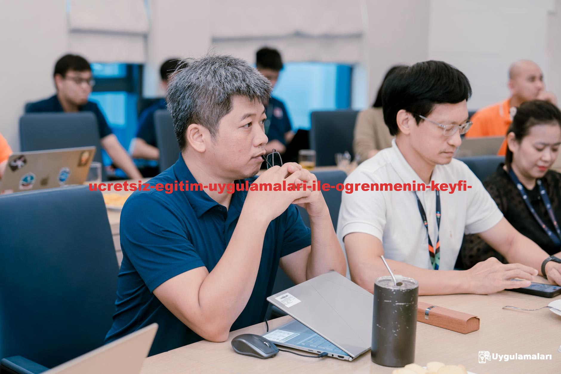 Engaged professionals in a corporate meeting room discussing ideas with laptops and notes.