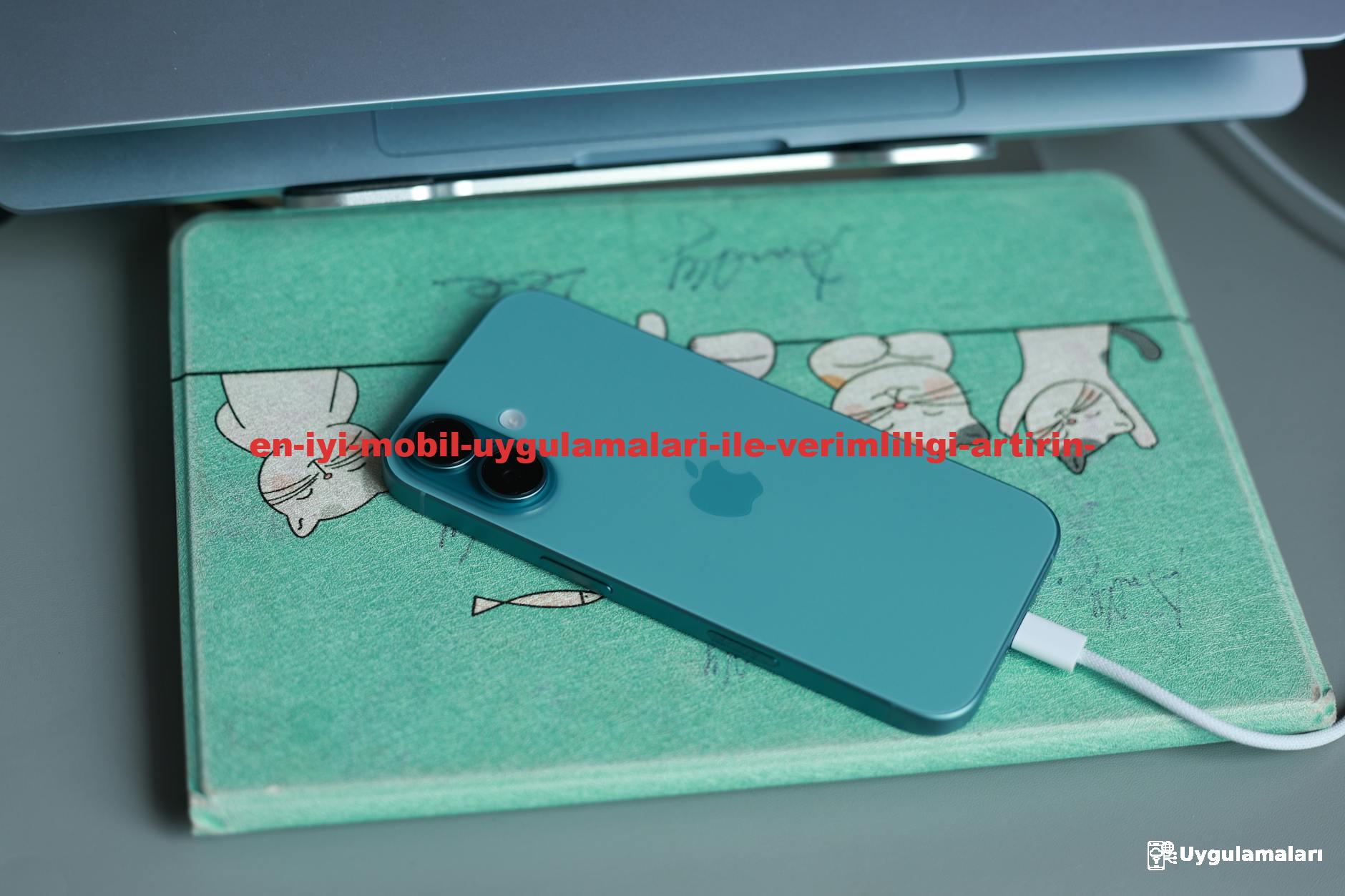 Blue smartphone charging on a cute cat-themed mat beneath a laptop. Perfect for tech and lifestyle content.