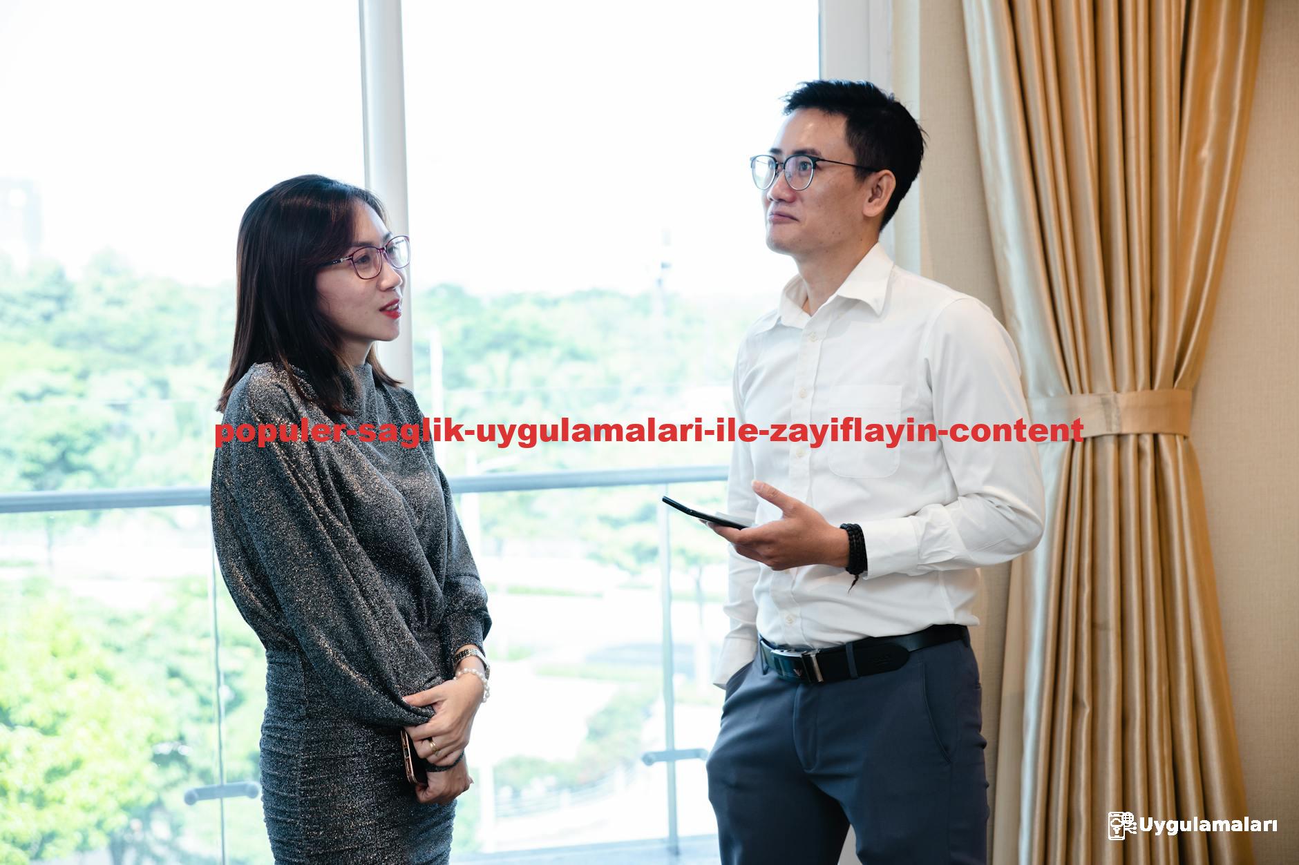 Two colleagues engaged in a business conversation indoors with a window view.