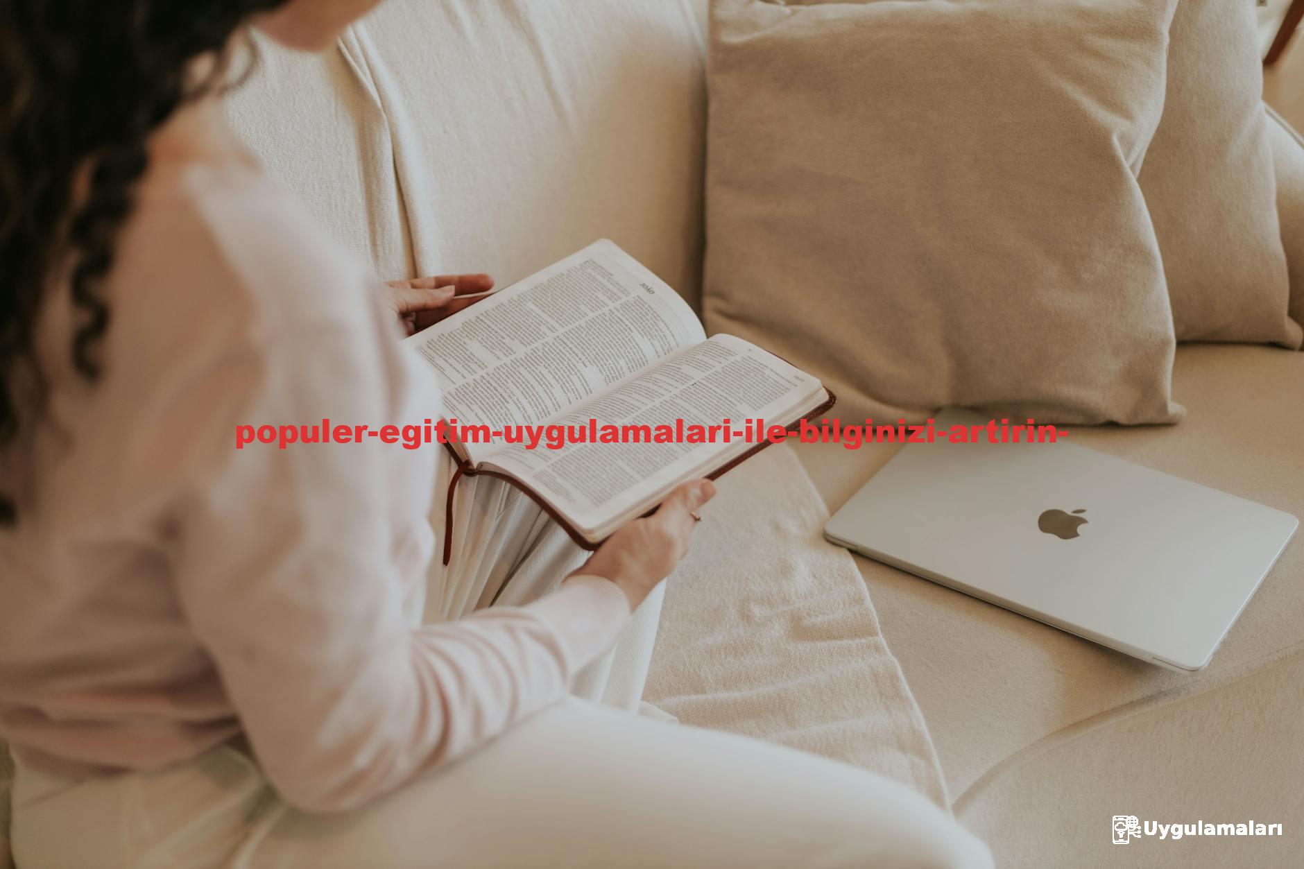 Woman reading a book on a cozy sofa with a laptop nearby. Ideal for lifestyle and relaxation themes.