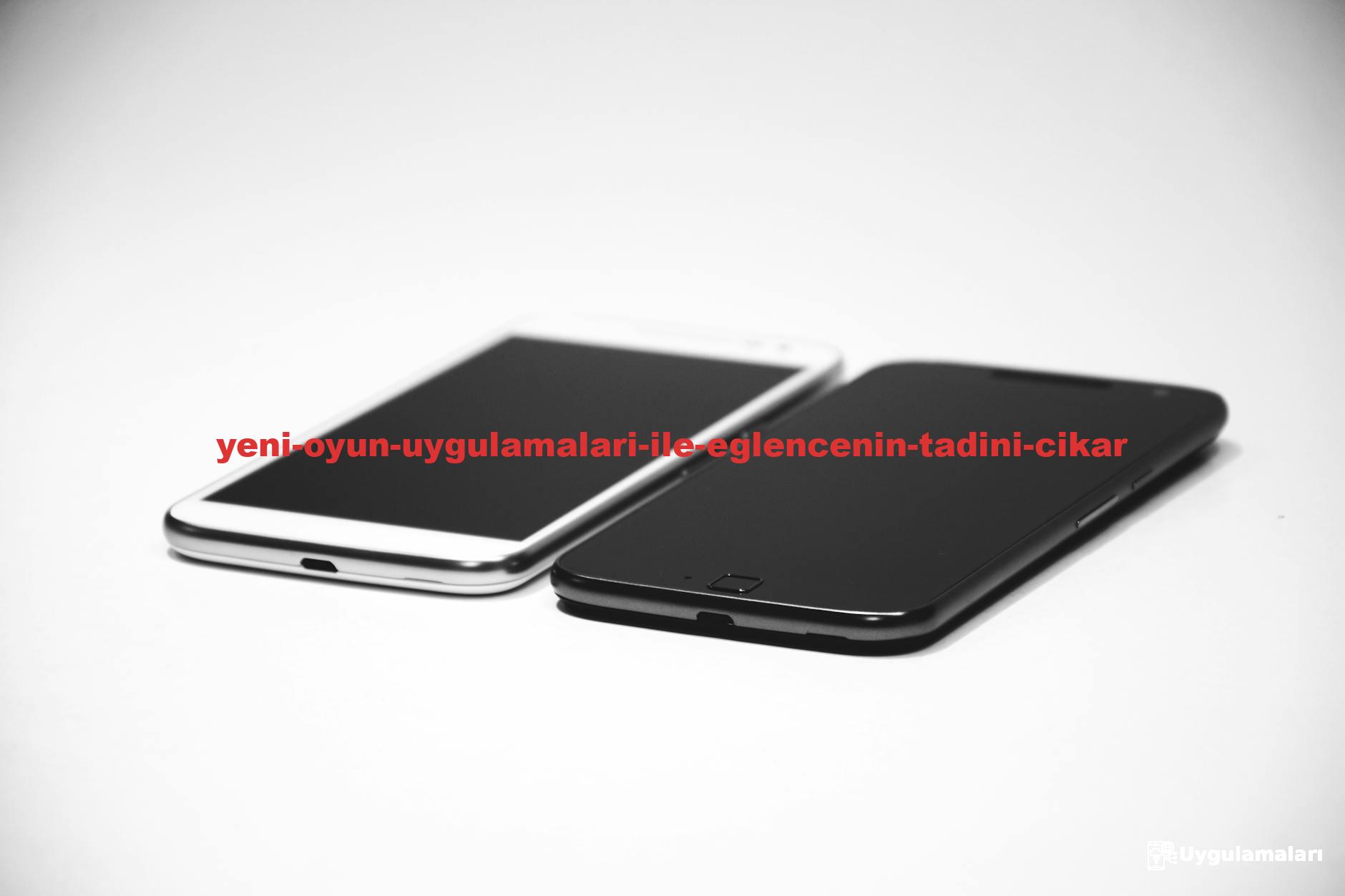 Two smartphones, one black and one white, placed on a white surface, showcasing modern design.